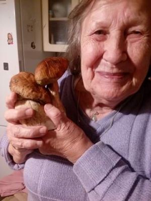 Starsza kobieta trzymająca grzyby leśne