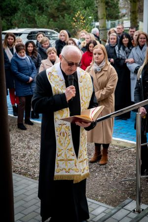 ksiądz błogosławi budynek
