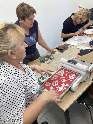 kobiety wykonują dekoracje na kartki świąteczne