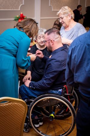 osoba na wózku inwalidzkim dzieli się opłatkiem z innymi